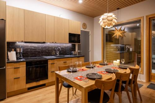 a kitchen with a table with chairs and a dining room at Premium Lapland Villa with jaguzzi in Rovaniemi