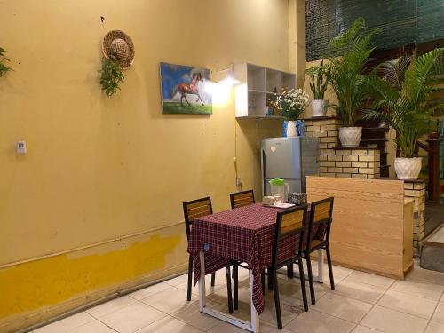 a table and chairs with a table and a refrigerator at Lumos Home Ha noi in Hanoi