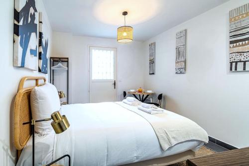 une chambre blanche avec un grand lit et une fenêtre dans l'établissement Studio équipé à 5 minutes de Paris - Montreuil -II, à Montreuil