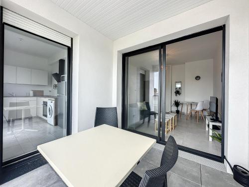 une cuisine et une salle à manger avec une table et des chaises dans l'établissement Le 121 - Appartement 101, à Quiberon