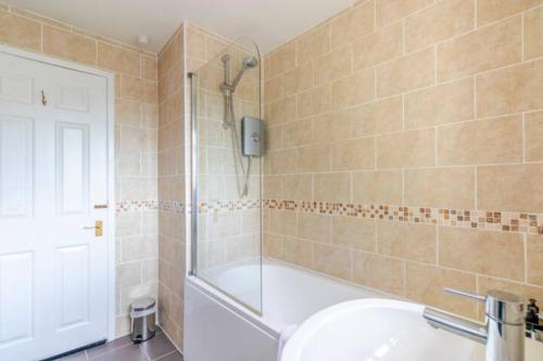 a bathroom with a shower and a sink and a tub at Trendy Sea View 2 bedroom Sleeps 6 - Free Parking in Bournemouth