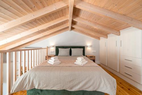 a bedroom with a large bed with wooden ceilings at Liopetro Suites in Aigio