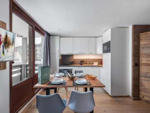 une cuisine avec une table et des chaises dans une pièce dans l'établissement Appartement rénové, ski aux pieds, cœur de Val Thorens - FR-1-640-34, à Val Thorens