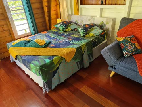 a bedroom with a bed and a chair and a window at La kaz nature bien-être in Petit-Bourg