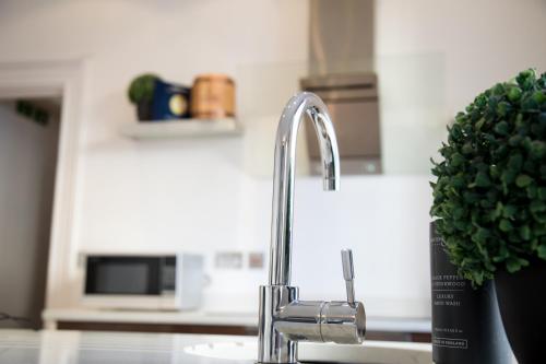 a kitchen sink with a faucet in a kitchen at Richmond Apartment in Liverpool
