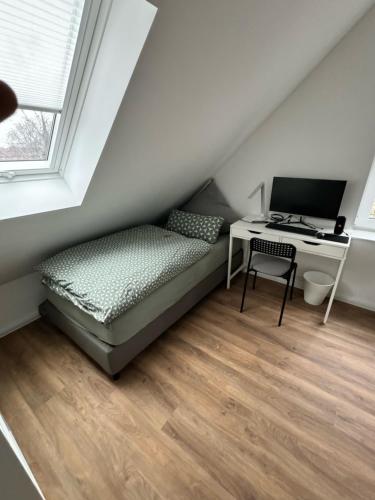 a bedroom with a bed and a desk with a computer at Modernes Apartment, voll eingerichtet inkl Parkplatz WLAN in Bremen