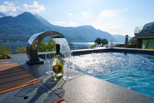 a bottle of wine and glasses next to a swimming pool at Villa Vittoria with private seasonal heated pool & shared sauna - Bellagio Village Residence in Oliveto Lario
