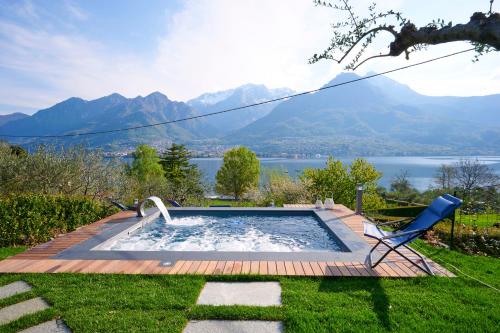 una piscina con sedia e vista sulle montagne di Villa Vittoria with private seasonal heated pool & shared sauna - Bellagio Village Residence a Oliveto Lario