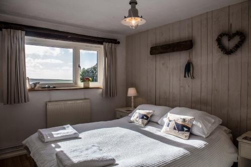 a bedroom with a large bed with a window at The Milking Parlour in Hartland