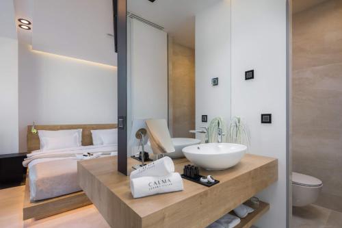 a bathroom with a sink and a mirror and a bed at Calma Ii in Starigrad-Paklenica