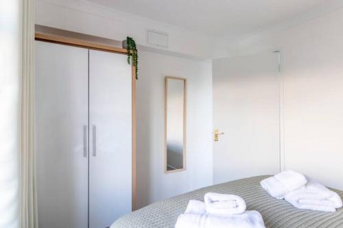 ボーンマスにあるLarge Sea View 2 bedroom Sleeps 6 - Free Parkingの白いベッドルーム(タオル付きのベッド付)