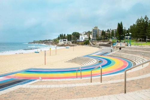 a beach with a rainbow painted on the sand at Coogee Beachside Getaway 2 in Sydney