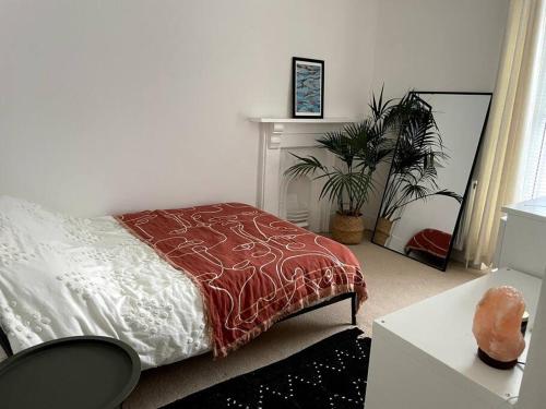 1 dormitorio con 1 cama y una maceta en Home in West by the Sea, en Llanelli
