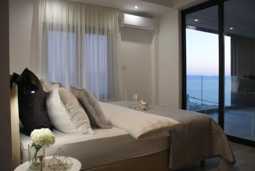 - une chambre avec un grand lit et une grande fenêtre dans l'établissement Luxury villa Astraeus 2 near Split, private pool, à Podstrana