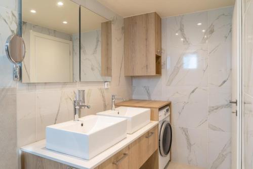 a bathroom with two sinks and a washing machine at Diamond Nevelo Quality Villas in Gerani