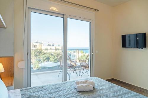 a bedroom with a bed with a view of a balcony at Diamond Nevelo Quality Villas in Gerani