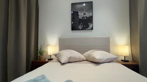 By nuit-parisienne : Superbe appartement avec SPA et terrasse privée في فيلومومبل: غرفة نوم عليها سرير ووسادتين