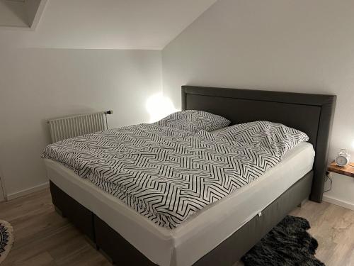 un letto con piumone bianco e nero in una camera da letto di Lichtdurchflutete Dachgeschoss-Wohnung mit großem Balkon a Bruckmühl