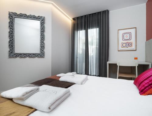 a bedroom with a large white bed with a mirror at Apartamentos Torre del Reloj in Jaca