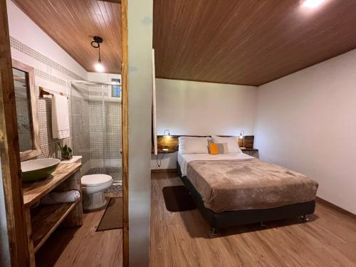 a bedroom with a bed and a bathroom with a sink at La Dama de los vientos in Cerro Azul