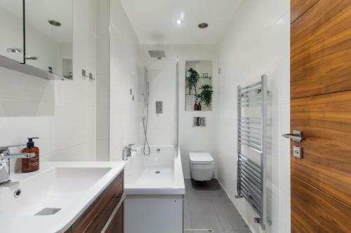 a white bathroom with a sink and a toilet at Paddington Gardens in London
