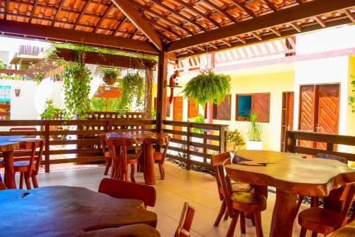 een restaurant met tafels en stoelen en een patio bij Pousada Villa Marceneiro Beach in Passo de Camarajibe