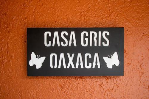 a sign on a wall with butterflies on it at Casa Gris Tule in Santa María del Tule