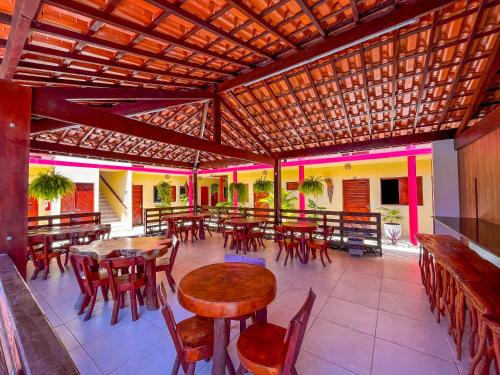 Passo de CamarajibeにあるPousada Villa Marceneiro Beachの木製のテーブルと椅子、テーブルと椅子が備わるレストラン