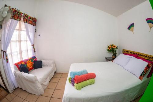 een slaapkamer met een bed met kleurrijke kussens erop bij Casa Gris Tule in Tule