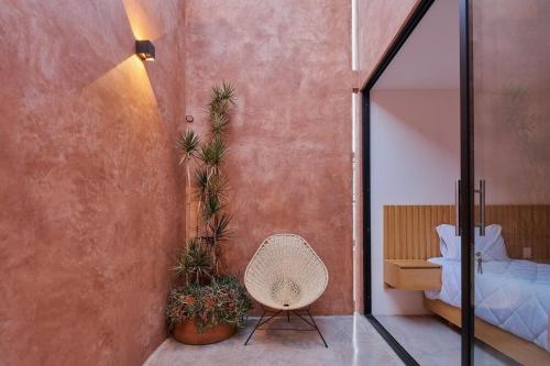 Hermosa casa ubicada en Oaxaca في مدينة أواكساكا: غرفة نوم بسرير وكرسي ومرآة