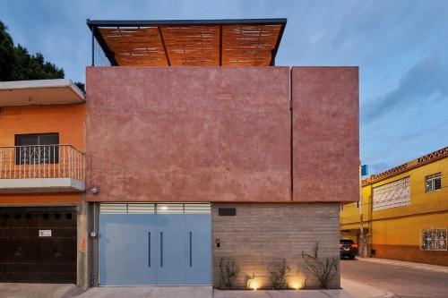 uma casa com uma grande parede de tijolos com um telhado de madeira em Hermosa casa ubicada en Oaxaca em Oaxaca de Juárez