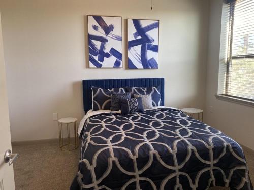 a bedroom with a blue bed with three paintings on the wall at Luxe Getaway Astros NRG Galleria in Houston