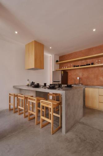 a kitchen with a counter and some wooden stools at Hermosa casa ubicada en Oaxaca in Oaxaca City
