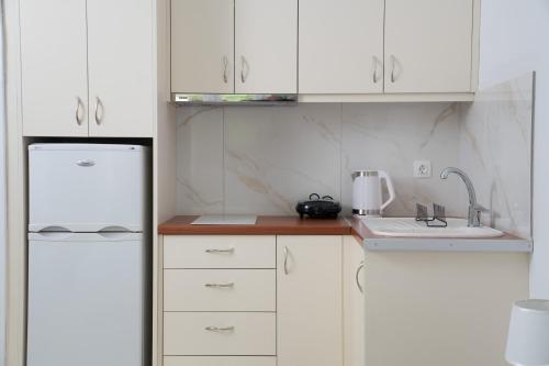 a kitchen with white cabinets and a white refrigerator at Delphian Colors - Green Edition in Delphi