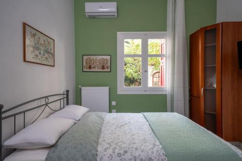 a bedroom with a bed with green walls and a window at Delphian Colors - Green Edition in Delphi