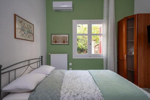 Un dormitorio con una cama con paredes verdes y una ventana en Delphian Colors - Green Edition, en Delfos