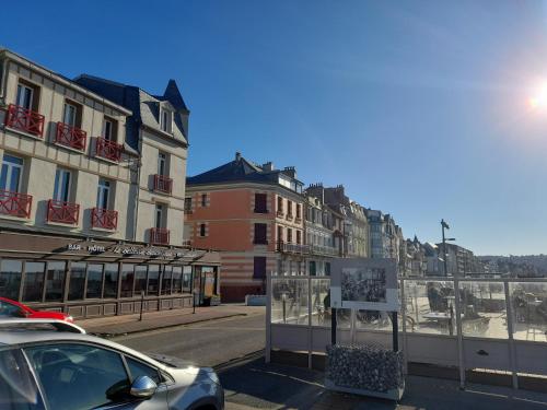 a car parked on a street next to buildings at "Le JUGUILI" 46m2 en front de Mer - 4 personnes - animaux OK - Entièrement rénové - Haut de gamme - wifi in Mers-les-Bains