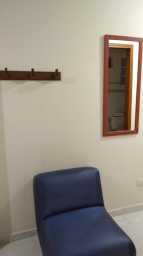 a blue chair in a room with a mirror at San Juan Del Lago in Pereira