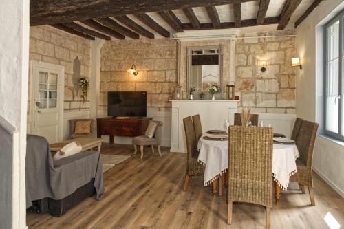 un salon avec une table et des chaises dans l'établissement Le gîte de l'Abbaye - Beaulieu-lès-Loches, à Beaulieu-lès-Loches
