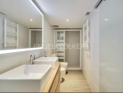 uma casa de banho branca com 2 lavatórios e um WC em apartamento exclusivo muy cerca ciudad Barcelona em Badalona