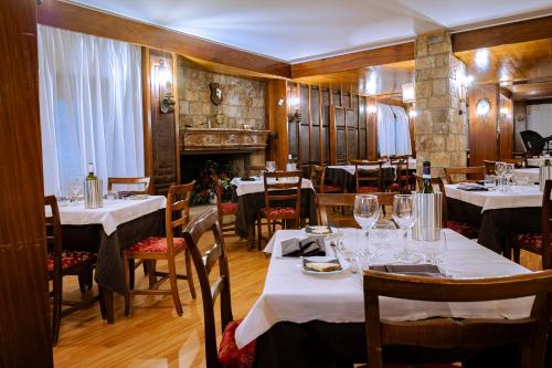 ペスカッセーロリにあるHotel Corona & Spaのテーブルと椅子(白いテーブルクロス付)が備わるレストラン