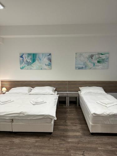 two beds in a room with white sheets at 111Apartments in Košice