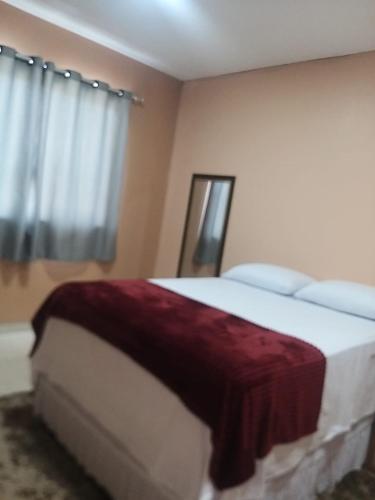 Un dormitorio con una cama con una manta roja. en Um lugar calmo e aconchegante, en Manaus