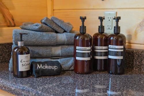 three bottles of wine sitting on a counter with towels at Lena Cabin Wooded Tiny Cabin - Hot Tub in Chattanooga