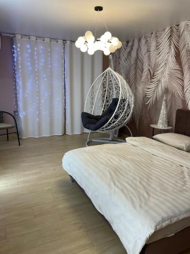 Pokój z łóżkiem i wiszącym krzesłem w obiekcie Квартира Тропики центр міста st Remisnycha 55a w mieście Czernihów