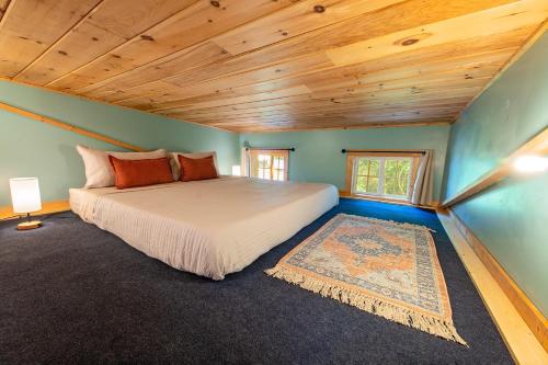 ein Schlafzimmer mit einem Bett und einer Holzdecke in der Unterkunft Lookout Tiny Cabin 5 Min To Downtown Chattanooga in Chattanooga