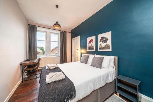 a bedroom with a large bed and a blue wall at Central Apartment - Industrial in Blairgowrie