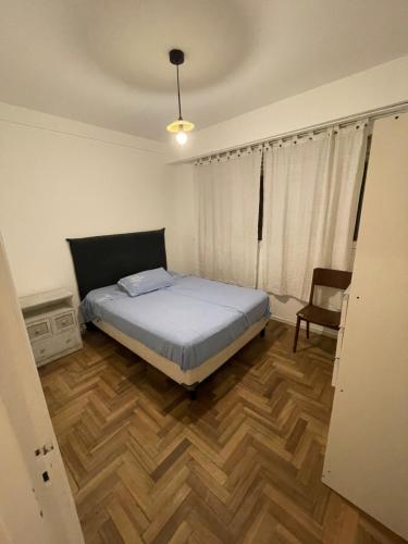 1 dormitorio con 1 cama y suelo de madera en Departamento en alquiler temporal mar del plata en Mar del Plata