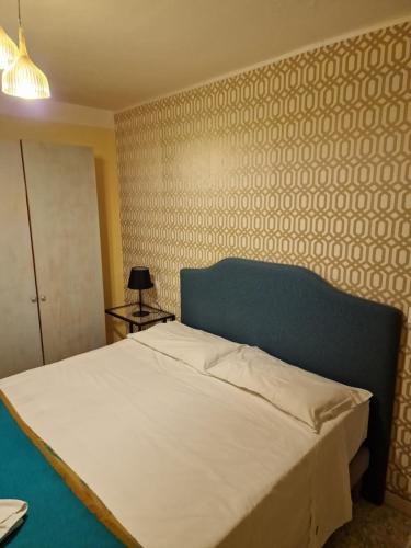 a bedroom with a white bed with a blue headboard at Locanda Al Centrale in Caprino Veronese