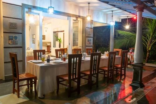 a dining room with a long table and chairs at Style Villa in Bentota